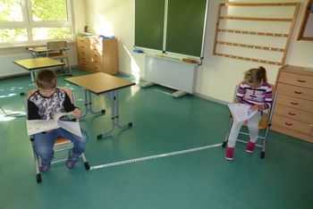 Die Kinder halten im Klassenraum den vorgeschriebenen Abstand ein.