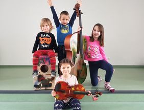 Luka, Ricardo, Elena und Enna freuen sich über die neuen Instrumente für den Kindergarten.